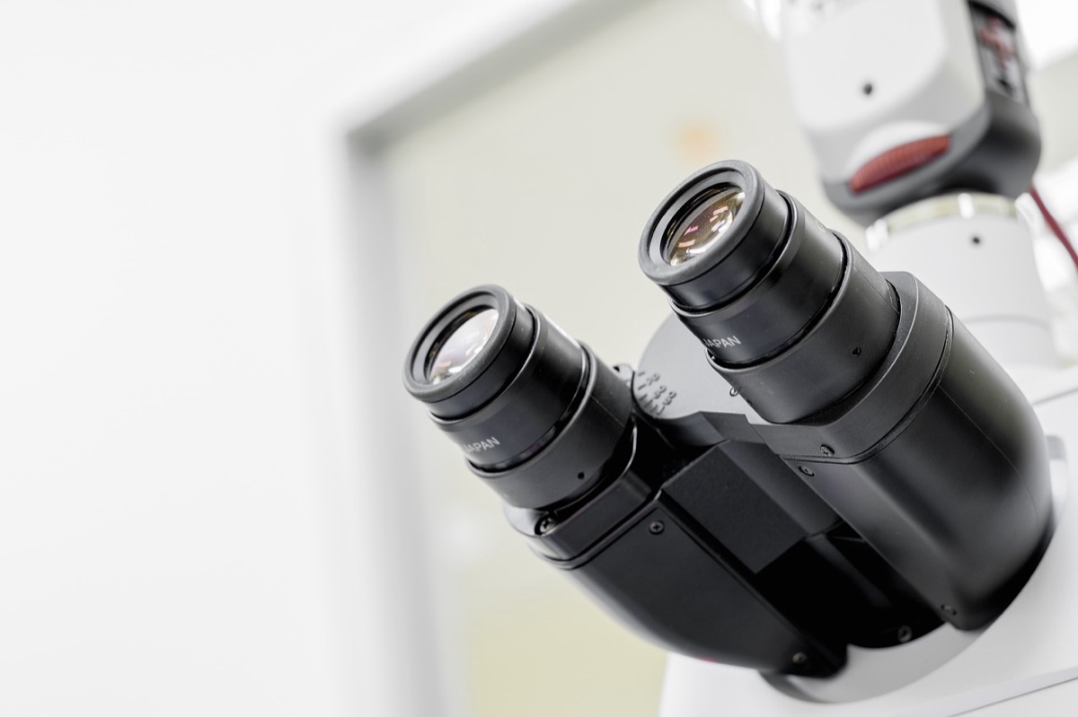 Een microscoop en glazen laboratoriumbuisjes voor cosmetische onderzoek.